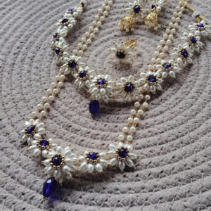 Parijatak Saaj blue pearl floral necklace set with matching jhumka earrings on white background