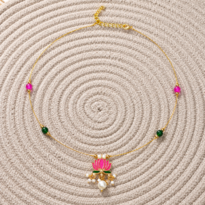 Lotus Invisible Necklace with pink and green beads displayed on a woven beige mat.