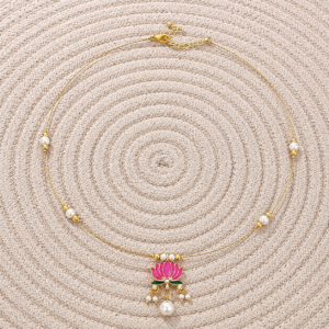 Lotus Invisible Necklace with White Beads displayed on a woven mat with white beads and a pink lotus pendant.