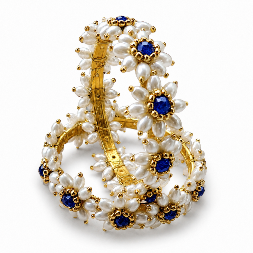 Pair of Parijatak Bangles with white floral beads and blue centre stones on a white background.