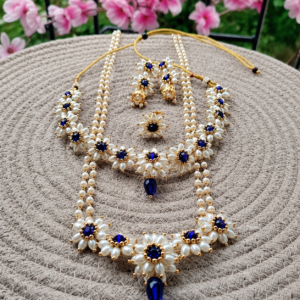 Parijatak Saaj Set - Blue displayed with matching mangalsutra, necklace, earrings, and ring on a woven mat.